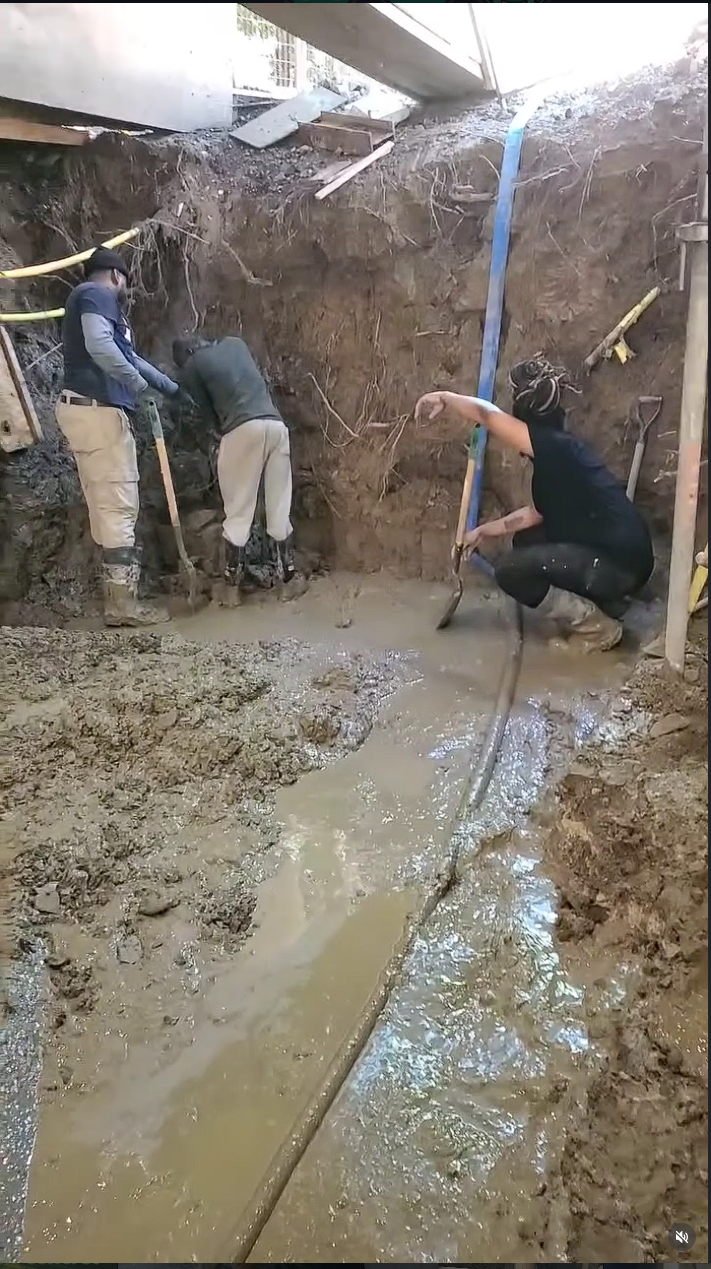 Crew hand-digging underpinning excavation