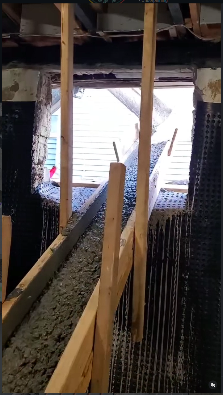 Walk-out basement opening with waterproofing membrane and concrete forms